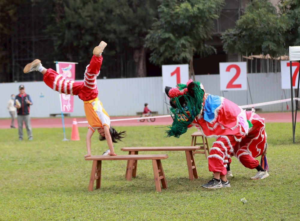 國中單獅混合東勢國中“弄獅”的人用前空翻的姿勢過橋。照片：臺南大學