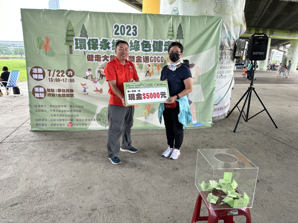 謝清良理事長（左）頒發最大獎現金5000元予幸運得主（運休協會提供）。