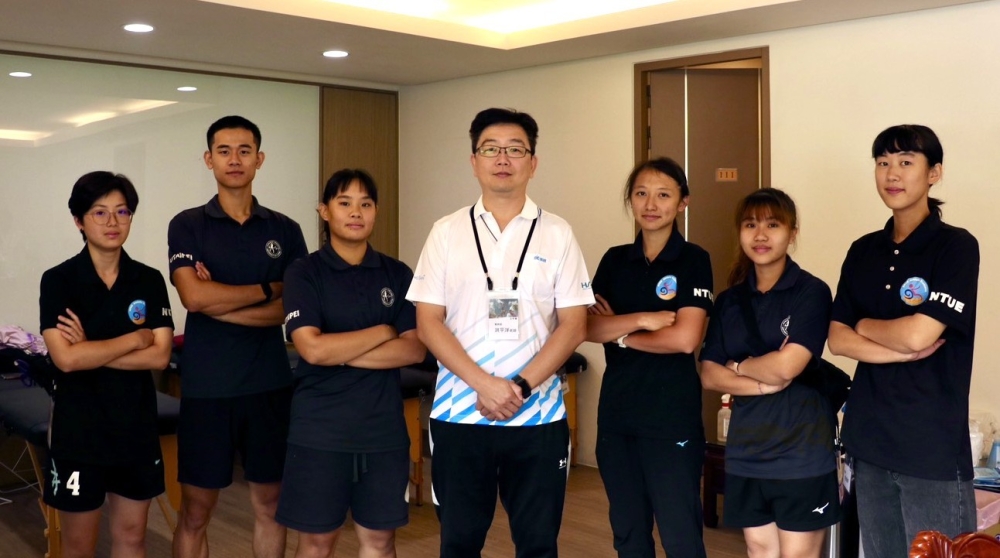 洪平洋老師(中)和台北市大、國北教大學生一起為參加永信杯排球賽的球員服務。許靜玟／攝影。