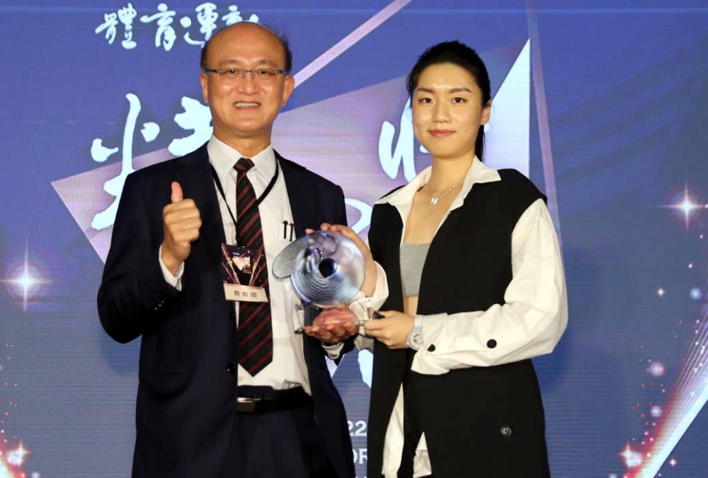 教育部次長兼代理署長林騰蛟(左)頒發最佳運動教練獎予劉文等教練，由劉教練女兒代領。