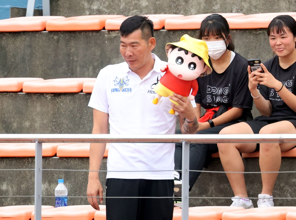 教練陳鴻傑帶「臘筆小新」當吉祥物為沛萱加油。林嘉欣／攝影。