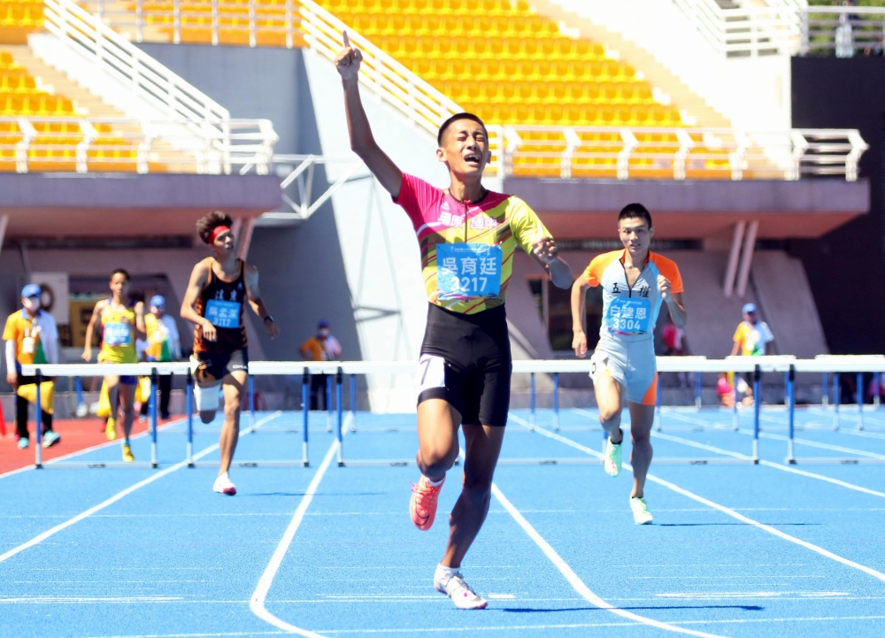 吳育廷穿著「鴛鴦鞋」在國男400公尺跨欄再添一金。林嘉欣／攝影。
