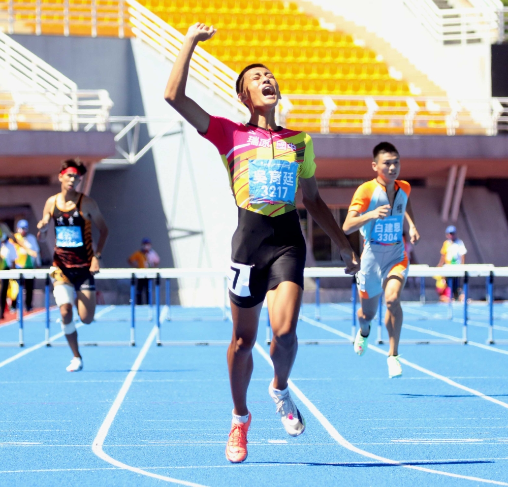 吳育廷穿著「鴛鴦鞋」在國男400公尺跨欄再添一金。林嘉欣／攝影。