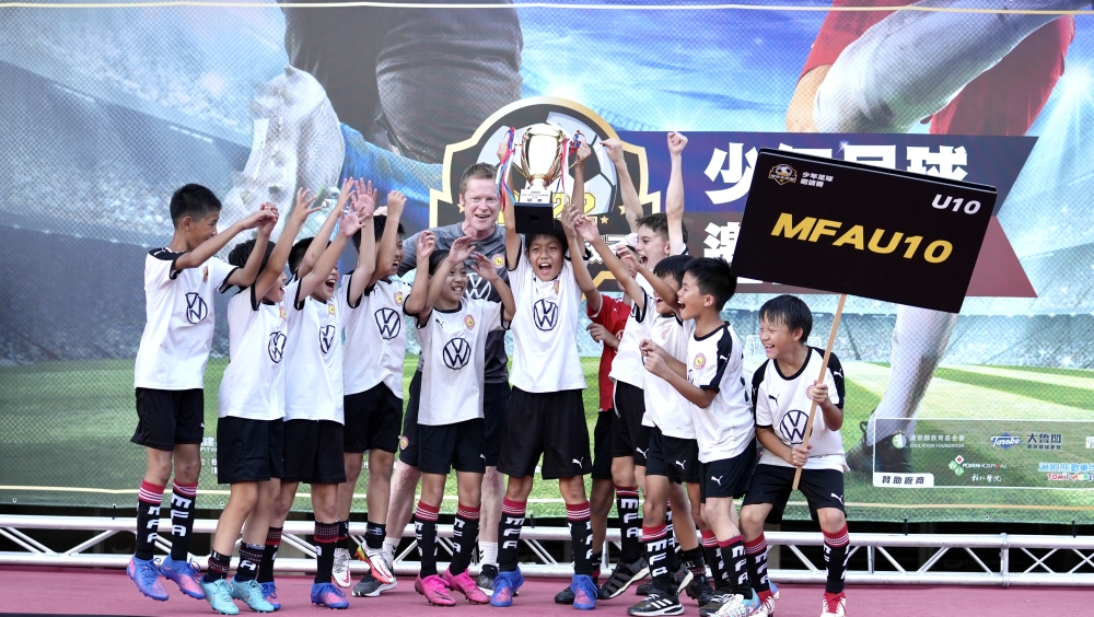 MFA U10拿下冠軍金盃，賽後球員及教練在頒獎臺上同歡。（大會提供）