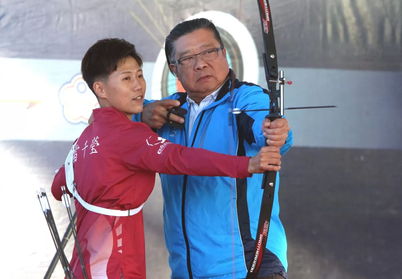 宋守智接受雷千瑩指導射箭。中華企業射箭聯盟/提供。
