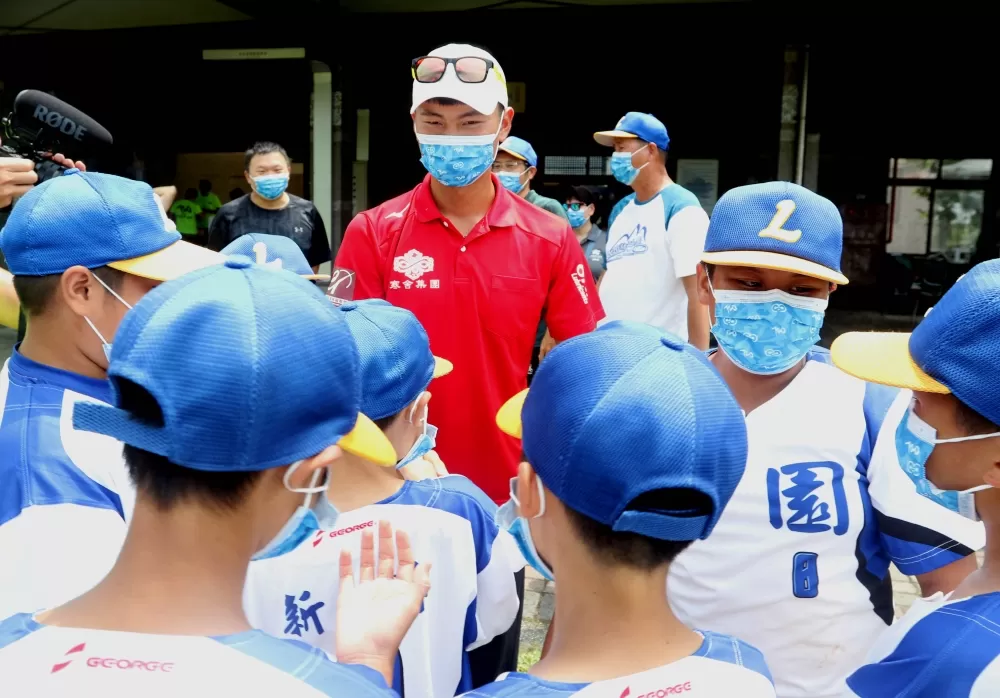 魏均珩和麗園國小少棒隊相見歡。720armour運動眼鏡/提供。