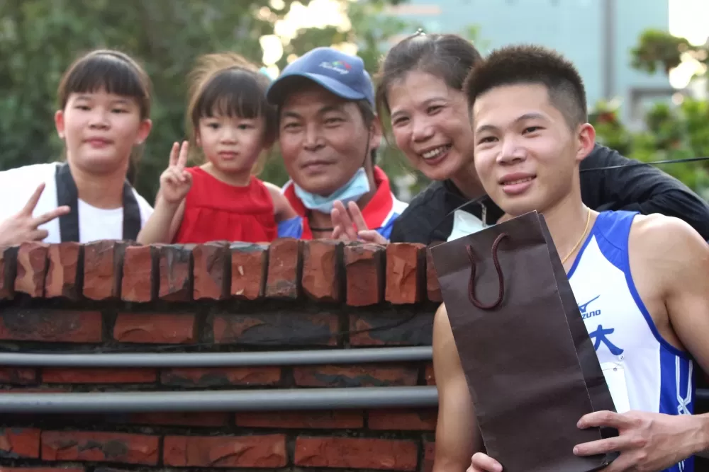 因疫情關係全大運不開放觀眾進場,李允辰的家人從圍牆外遞生日禮物給他。林嘉欣/攝影。