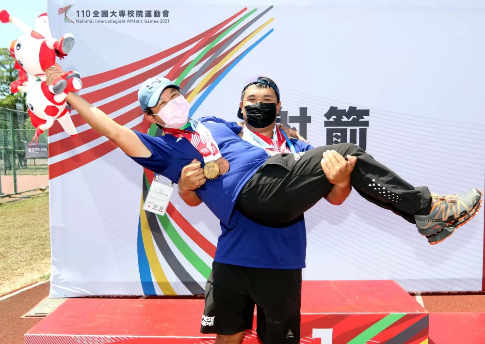 今年全大運混雙奪金後,潘宇平開心抱起搭檔和師父陳麗如。林嘉欣/攝影。