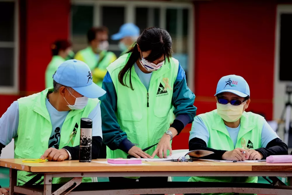 全田賽大會工作人員別上黃絲帶，紀念堅守崗位至生命最後一刻的徑賽裁判長陳楙樟。林嘉欣／攝影。