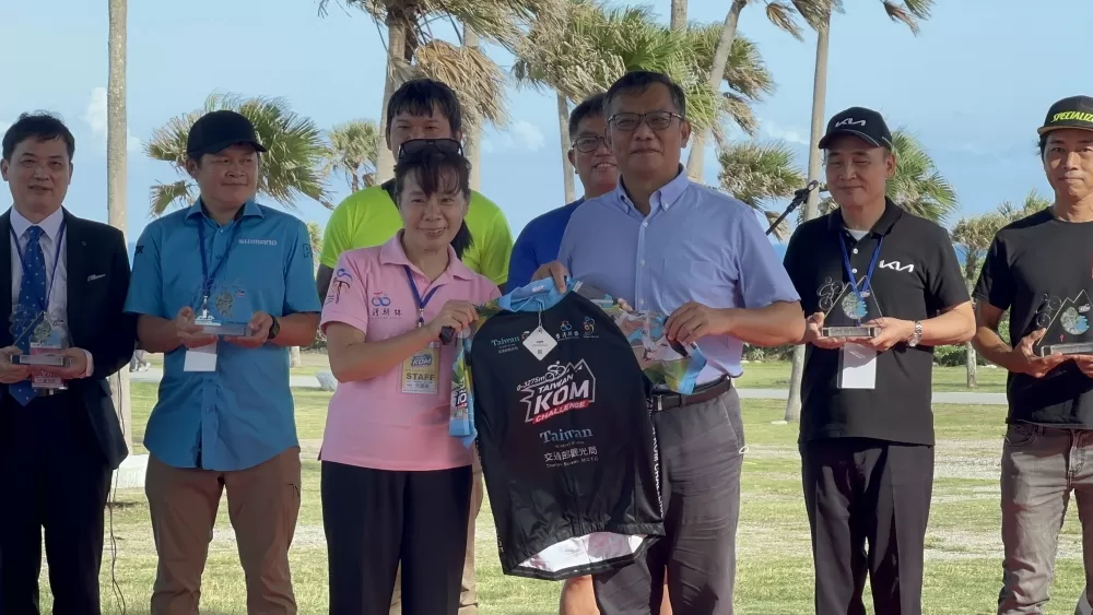 騎士協會秘書長何麗卿致贈紀念車衣給花東縱谷國家風景管理處處長郭振陵。中華民國自行車騎士協會提供。