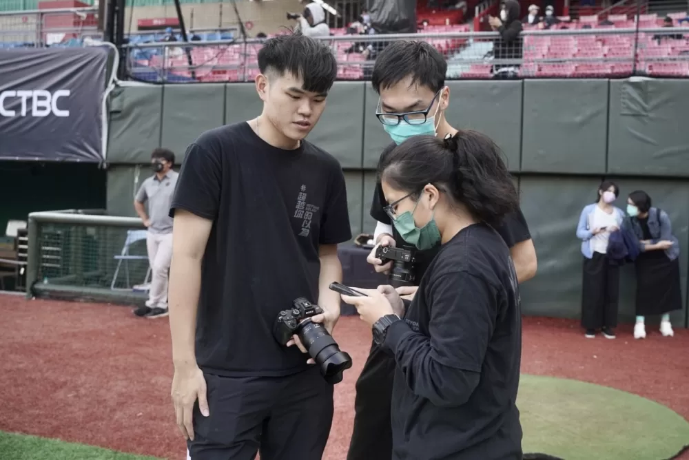 國體學生於開幕戰現場討論拍攝與社群內容。謝宇翔／攝影。
