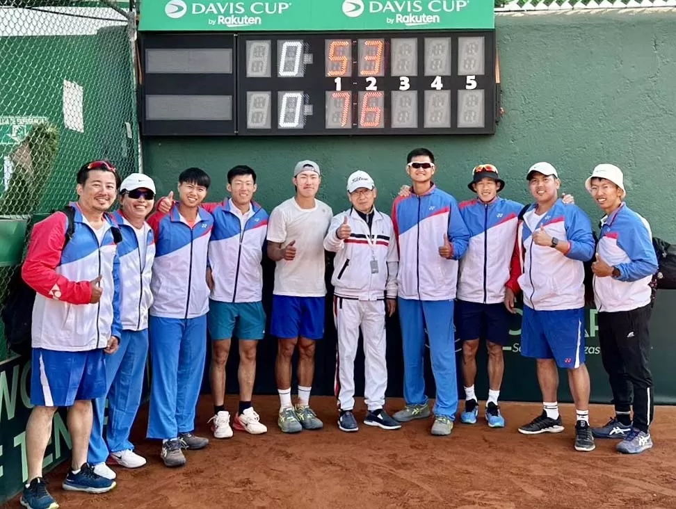 許育修(左五)第二場直落二贏球後,大家在計分板前合影。左四是曾俊欣。網球協會提供。