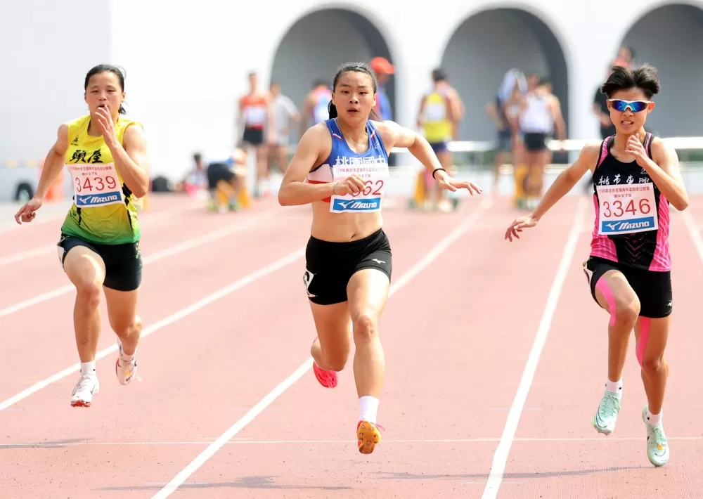 桃園國中黃郁庭（中）在國女100公尺決賽破大會再達亞青少。林嘉欣／攝影。