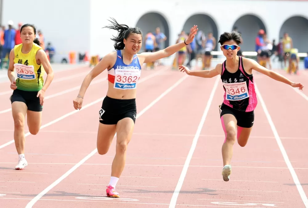 桃園國中黃郁庭（中）在國女100公尺決賽破大會再達亞青少。林嘉欣／攝影。