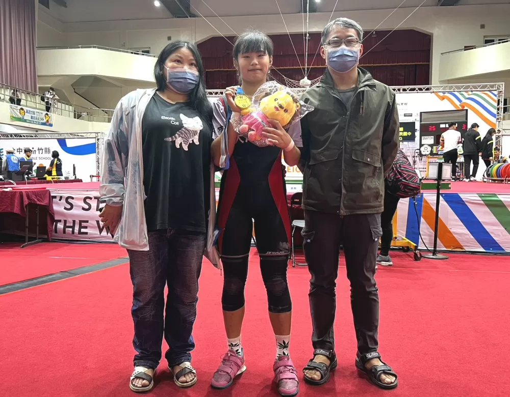 大成國中傅珮珊(中)三破大會奪金,開心和爸媽合照。李健宇/提供。