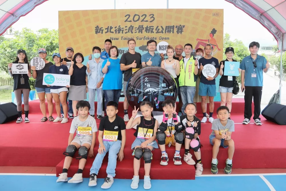 新北市教育局長張明文（中間站立綠上衣）參加第一屆新北衝浪滑板公開賽開幕儀式後與來賓、選手合影。（新北市教育局提供）