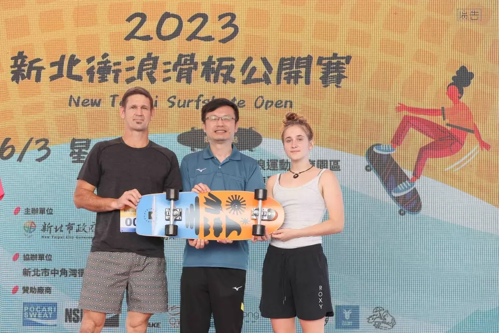 紐西蘭選手父女檔致贈衝浪滑板予新北市政府並由教育局長張明文（中）代表接受。（新北市教育局提供）