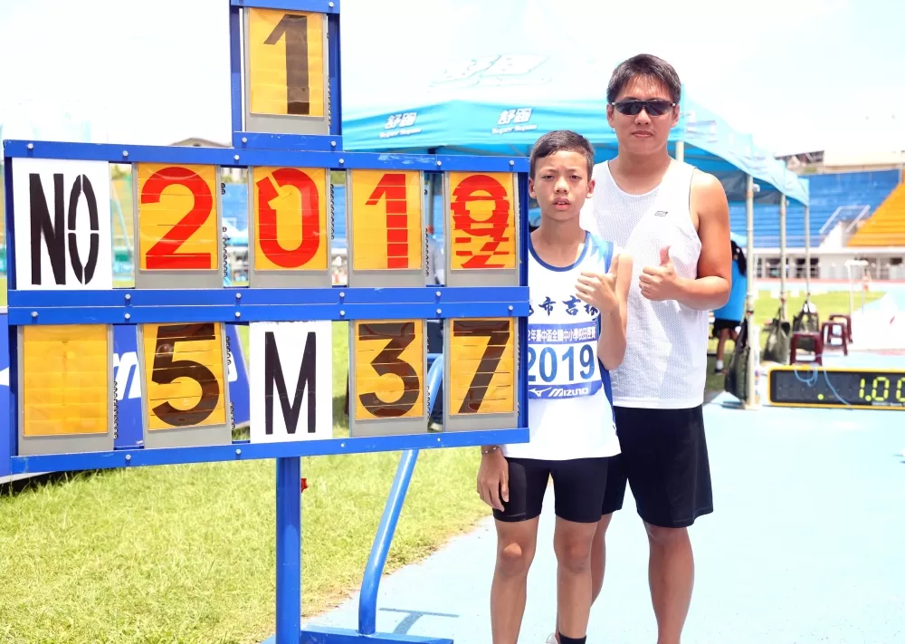林樂昕在國小男童組跳遠5.37公尺破大會後和教練翁嘉隆合影。林嘉欣／攝影。