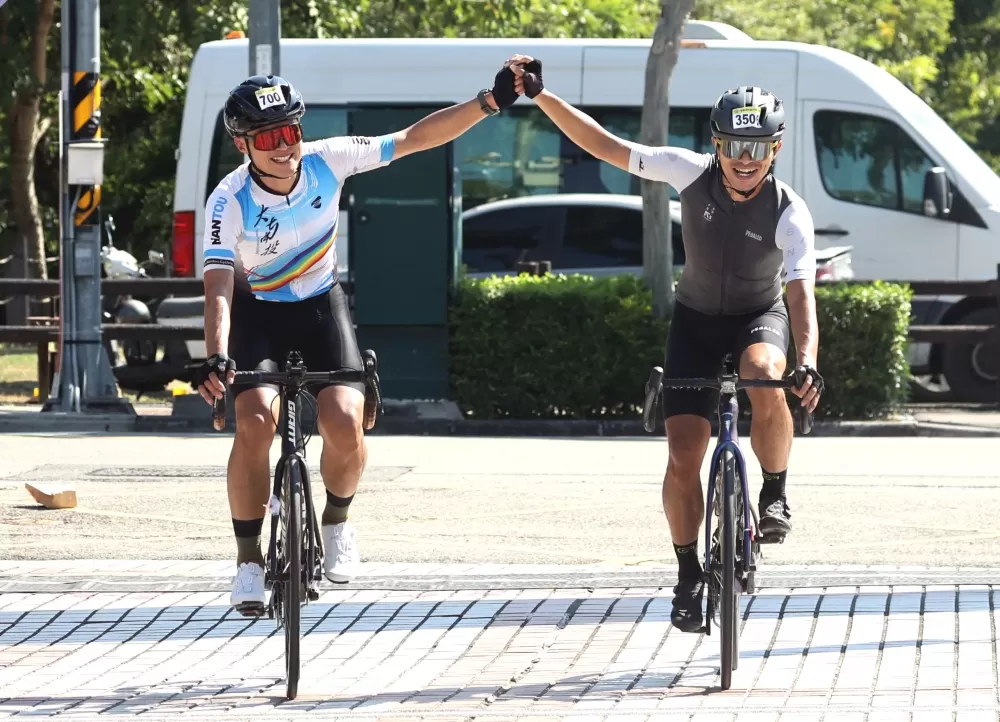 大南投車隊林建利(左)和FAN!S Cycling Team 陳俊翰攜手抵達終點。中華民國自行車騎士協會提供。