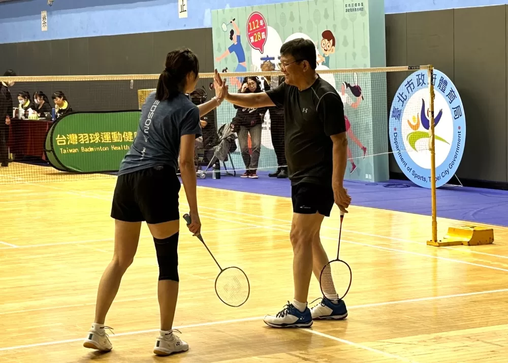 臺北市政府副秘書長林哲宏(右)與隊友何郁慧(左)擊掌慶祝得分(大會提供)。