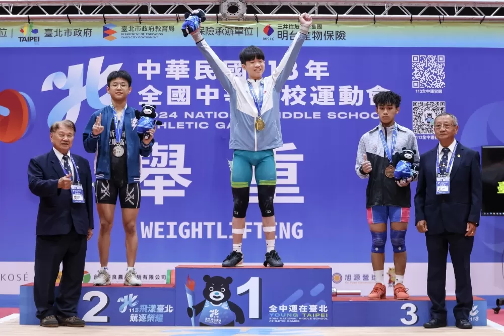 臺中市成功國中王昱鈞在全運會舉重項目國男55公斤級三破大會紀錄摘金，在頒獎台上振臂狂喝。（臺北市政府教育局提供）