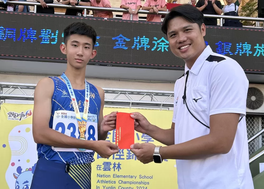 徐唯宸(左)200公尺飆23秒26破全國國小紀錄，花蓮田徑協會總幹事陳智傑頒發立即獎。陳智傑提供。