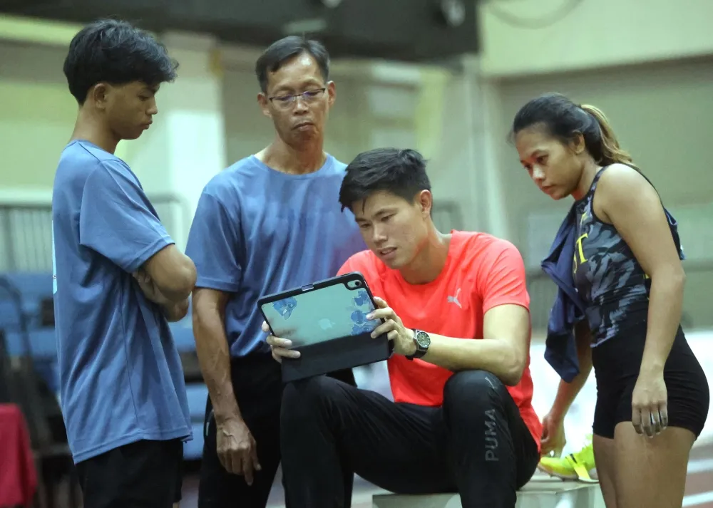 EJ Obiena(右二)每一跳跳完，都會和父親(左二)回放影片找問題。林嘉欣／攝影。